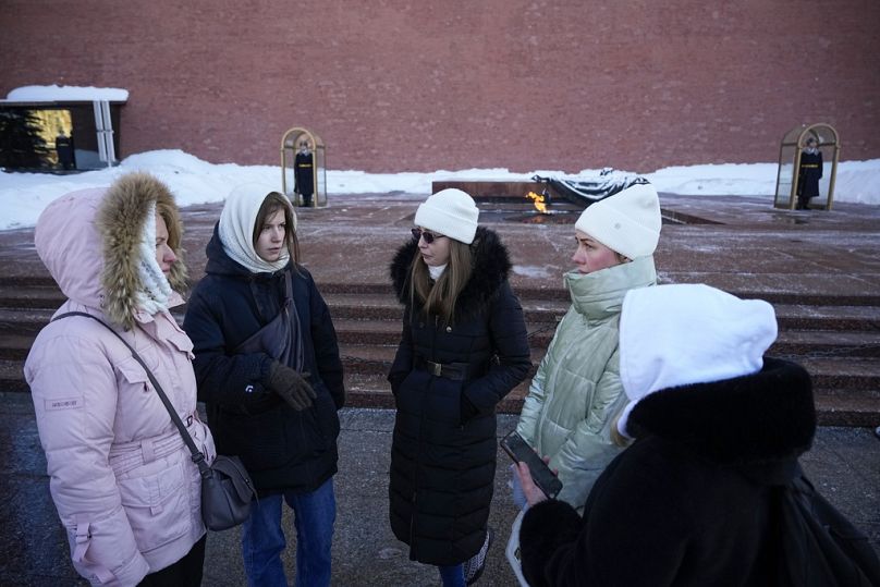 Wives of Russian soldiers mobilized for fighting in Ukraine talk to each other after laying flowers at the Unknown Soldier's Tomb at the Kremlin wall in Moscow, Russia.