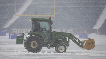 Workers remove snow from Highmark Stadium in Orchard Park, N.Y., Sunday Jan. 14, 2024