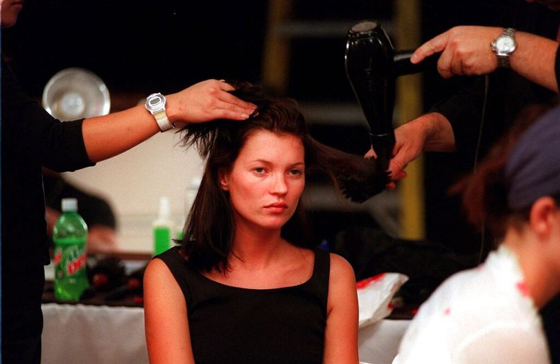 Kate Moss has her hair styled backstage before the start of the runway show of the Marc Jacobs Spring 2000 collection in New York Monday 13 September 1999.