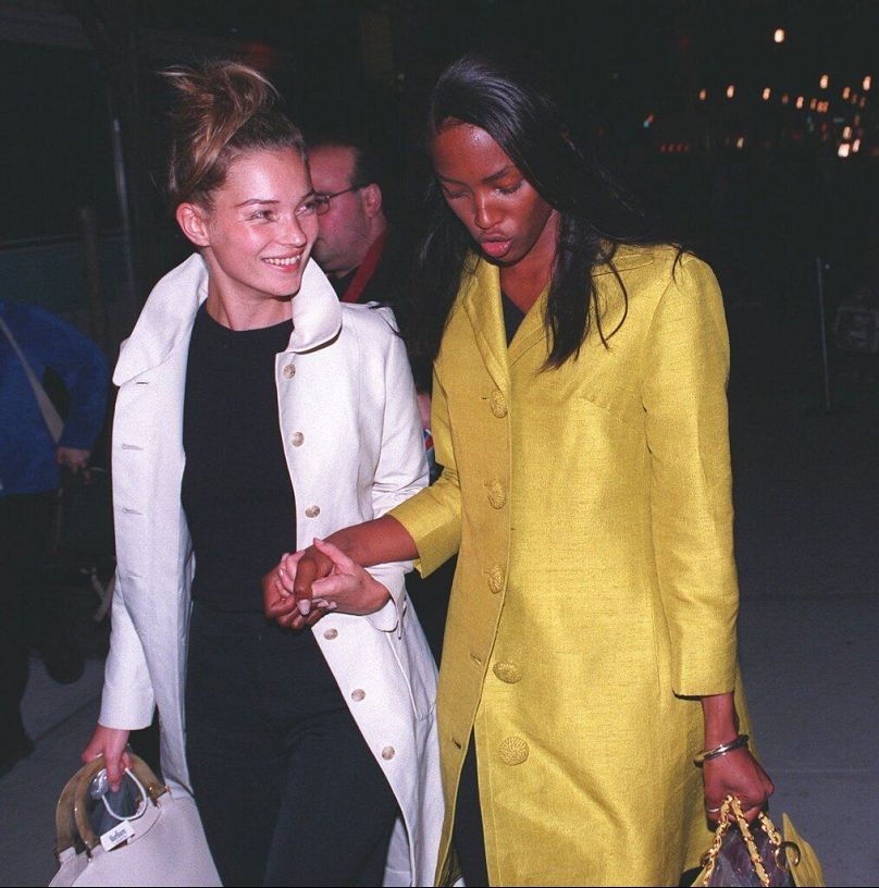 Kate Moss, left, and Naomi Campbell hold hands as they leave after the Versace show April 12, 1997 during Fashion Week in New York.