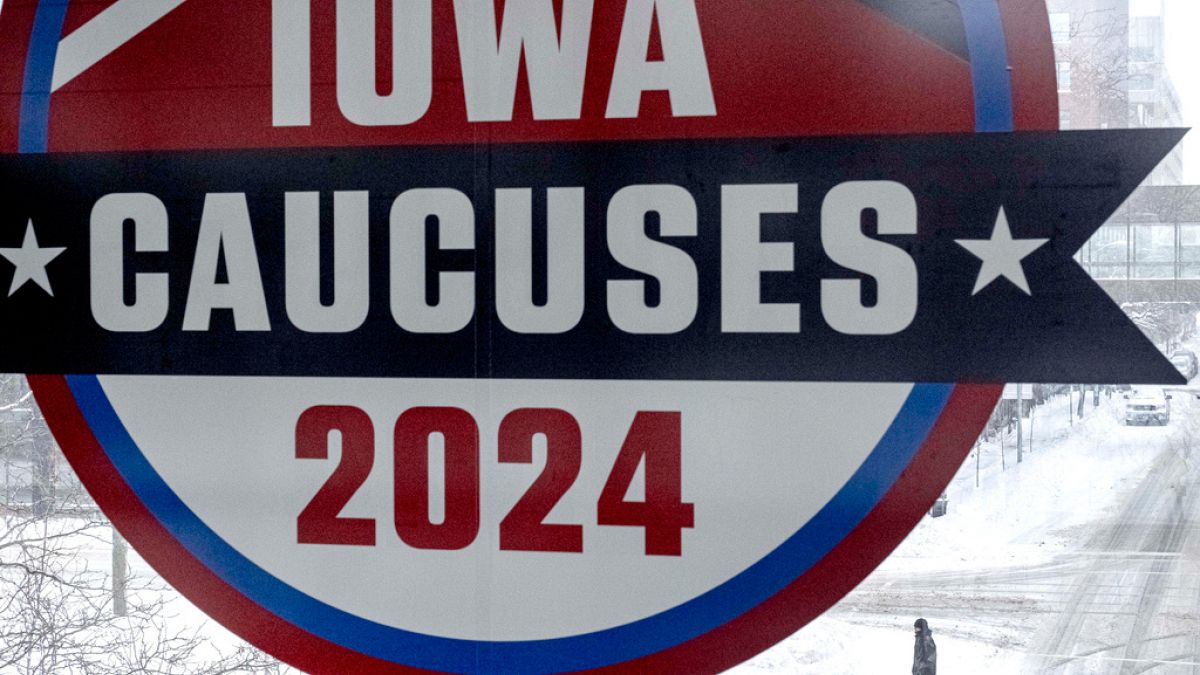 Iowa'ya bağlı Des Moines şehir merkezinde eyalet seçimlerine ilişkin bir tabelanın altında yürüyen bir kişi