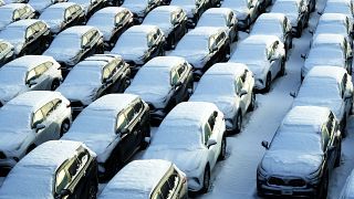 Snow covered vehicles sit in a rental car parking lot at the O'Hare International Airport in Chicago, Sunday, Jan. 14, 2024. 