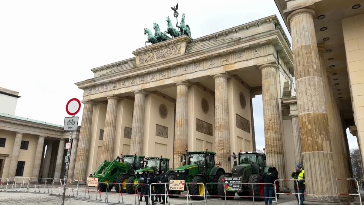 Des agriculteurs marchent entre des tracteurs alors qu'ils arrivent pour la manifestation à Berlin, le lundi 15 janvier 2024.