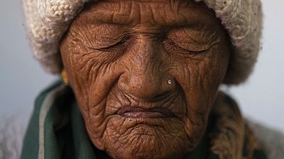 An elderly woman prays at a church in Kathmandu, Nepal. Dec. 25, 2023. 
