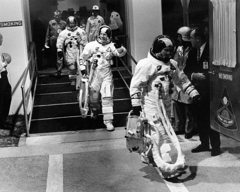 Apollo 8 astronotları, giyinmiş bir şekilde, 21 Aralık 1968'de Cape Kennedy'den Ay misyonu için Saturn V roketine götüren araçlarına doğru yürüyor