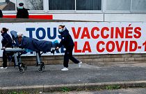 Женщину несут на носилках в центр вакцинации COVID-19 группы больниц Южного Иль-де-Франса в Мелене, в пригороде Парижа, февраль 2021 года.