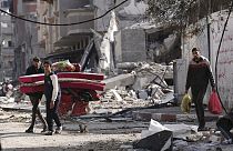 Palestinians walk through destruction by the Israeli bombardment in the Nusseirat refugee camp in Gaza Strip (January 2024)