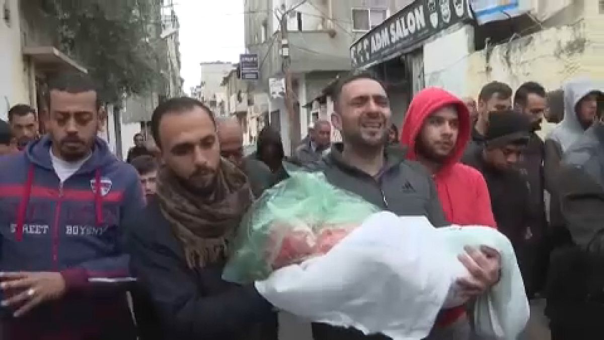 فلسطيني يحمل جثمان ابنته البالغة من العمر ثلاث سنوات والتي قُتلت بغارة إسرائيلية.