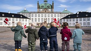 Niños ondean banderas danesas mientras celebran el cumpleaños de la ex reina Margarita de Dinamarca, en Fredensborg, Dinamarca, el 16 de abril de 2021.