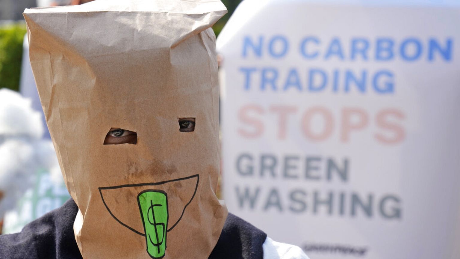 An activist covers her head with a paper bag during a climate protest in Jakarta, Indonesia, Friday, Nov. 5, 2021. 
