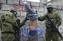 Dos soldados detienen brevemente a un joven para comprobar si tiene tatuajes relacionados con pandilleros, mientras patrullan la zona sur de Quito, Ecuador.