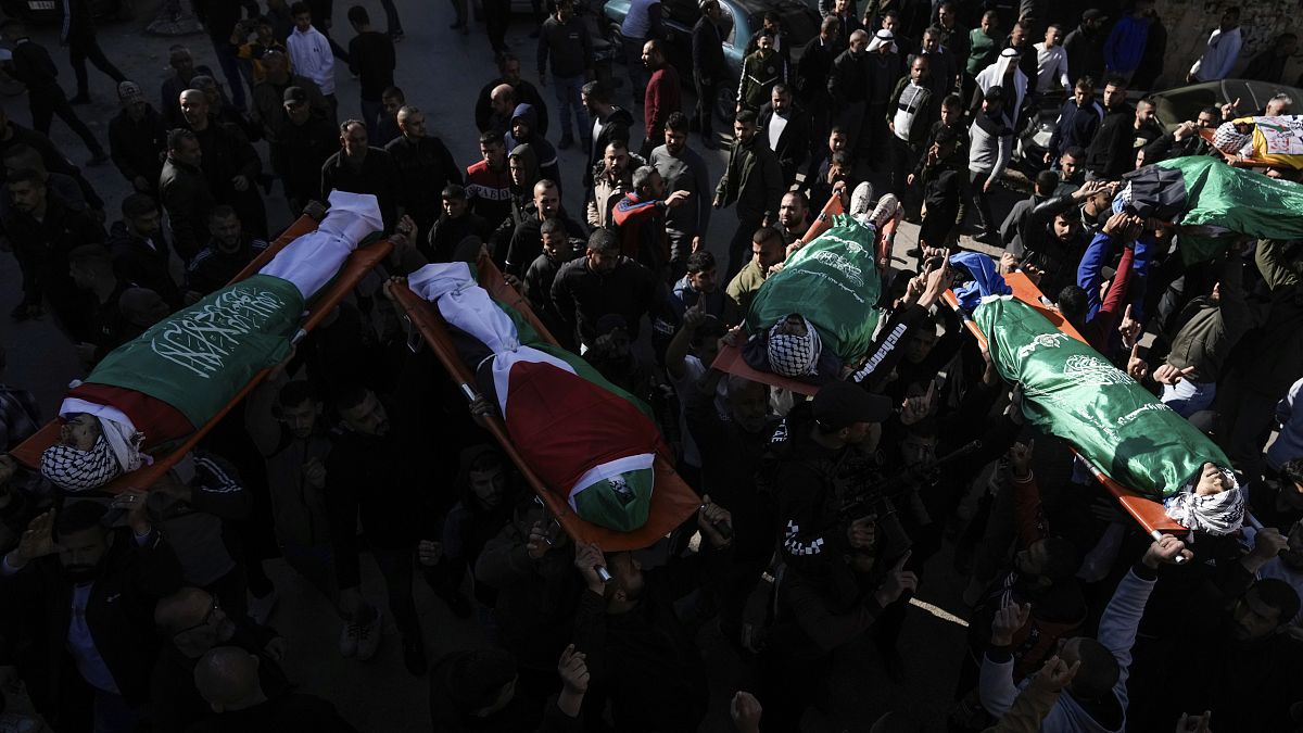 Gyászolók viszik hat palesztin férfi, Hamász-zászlóval bevont koporsóját a temetésükön a ciszjordániai Dzsenínben 2024. január 7-én