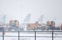 Snow clearing vehicles drive past parked airplanes at Frankfurt Airport during heavy snowfall in Frankfurt am Main, Germany, Thursday, Jan 18, 2024.