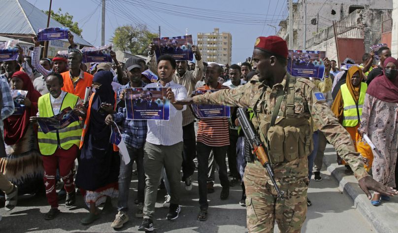 A Somali soldier controls the crowd as thousands of people attend a protest rally in Mogadishu, January 2024