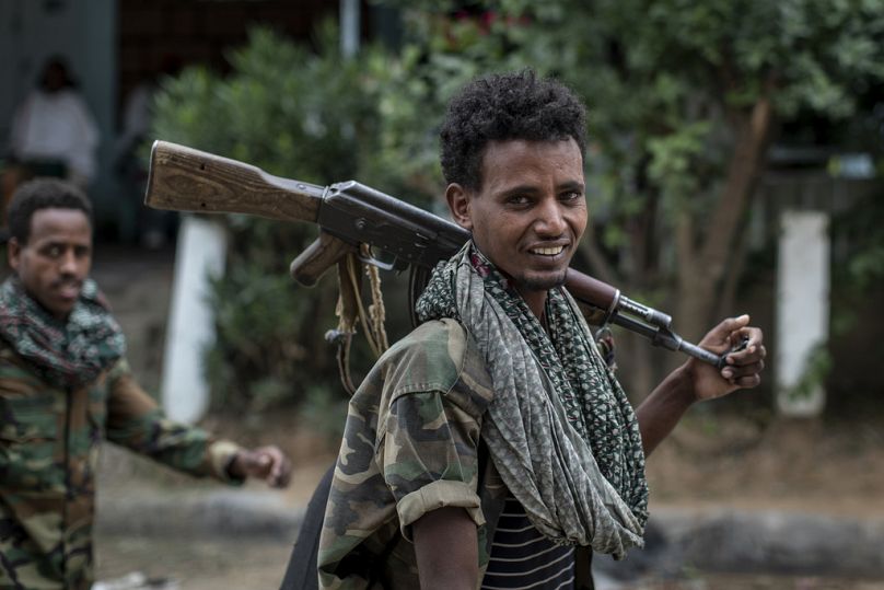 Fighters loyal to the Tigray People's Liberation Front (TPLF) walk along a street in the town of Hawzen in the Tigray region of northern Ethiopia, May 2021