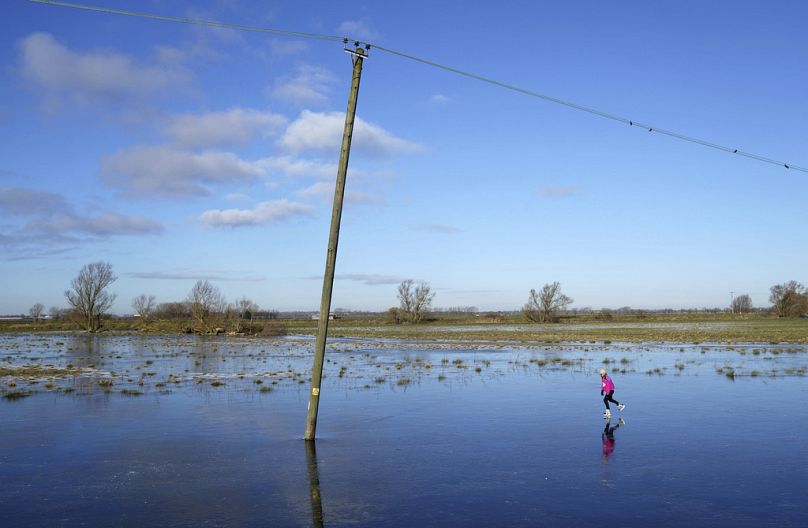 A person skates on a frozen flooded field in Upware, Cambridgeshire, England on Thursday