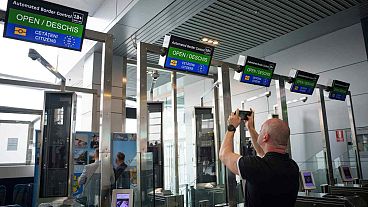 A man takes a picture of Non-Schengen automatic border control gates, at the Henri Coanda International Airport in Otopeni, near Bucharest, Romania, Thursday, March 28, 2024.