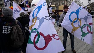Police officers demonstrate with flags turning the olympic rings as handcuffs during a demonstration Wednesday, Jan. 10, 2024 in Paris. 