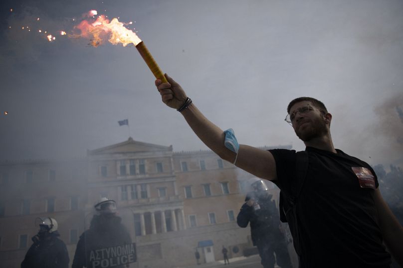 A protester holds a flare during a demonstration outside the Greek Parliament, Athens, Greece, on Thursday, Jan. 18, 2024.