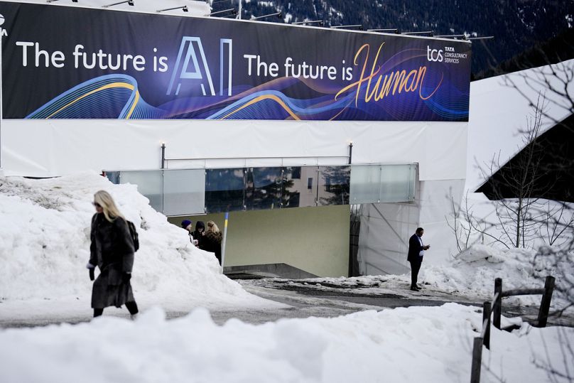 A huge advertising banner with a slogan about AI is fixed at a building at the Davos Promenade,