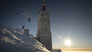 A paraglider takes off from the snow-covered Mont Ventoux, southeastern France, Saturday, Jan. 13, 2024