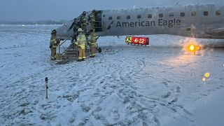 رجال الإطفاء في مطار روتشستر الدولي يساعدون الركاب على النزول من طائرة انزلقت على المدرج بسبب الثلوج. 2024/01/18
