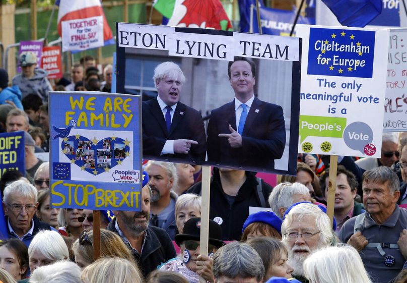 Des partisans de l'UE tiennent une pancarte montrant les ex-Premiers ministres Boris Johnson et David Cameron lors d'une marche du mouvement "A people's vote" à Londres, 2019