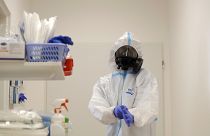Медицинский работник надевает средства индивидуальной защиты (СИЗ) перед уходом за пациентами с COVID-19 в больнице в Чешской Республике.