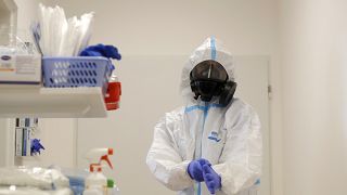 Un agent de santé revêt un équipement de protection individuelle (EPI) avant de s'occuper de patients atteints du virus COVID-19 dans un hôpital de la République tchèque.