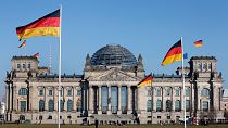 الأعلام الألمانية ترفرف أمام مبنى الرايخستاغ، مقر البرلمان الاتحادي الألماني (البوندستاغ)، في برلين.