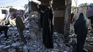 Palestinians look at the destruction after an Israeli strike in Rafah, southern Gaza Strip, Thursday, Jan. 18, 2024