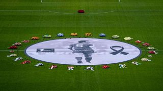 Flower wreaths surround a photograph of Bayern and Germany legend Franz Beckenbauer on the pitch of the Allianz Arena in Munich, Germany, Friday, Jan. 19, 2024