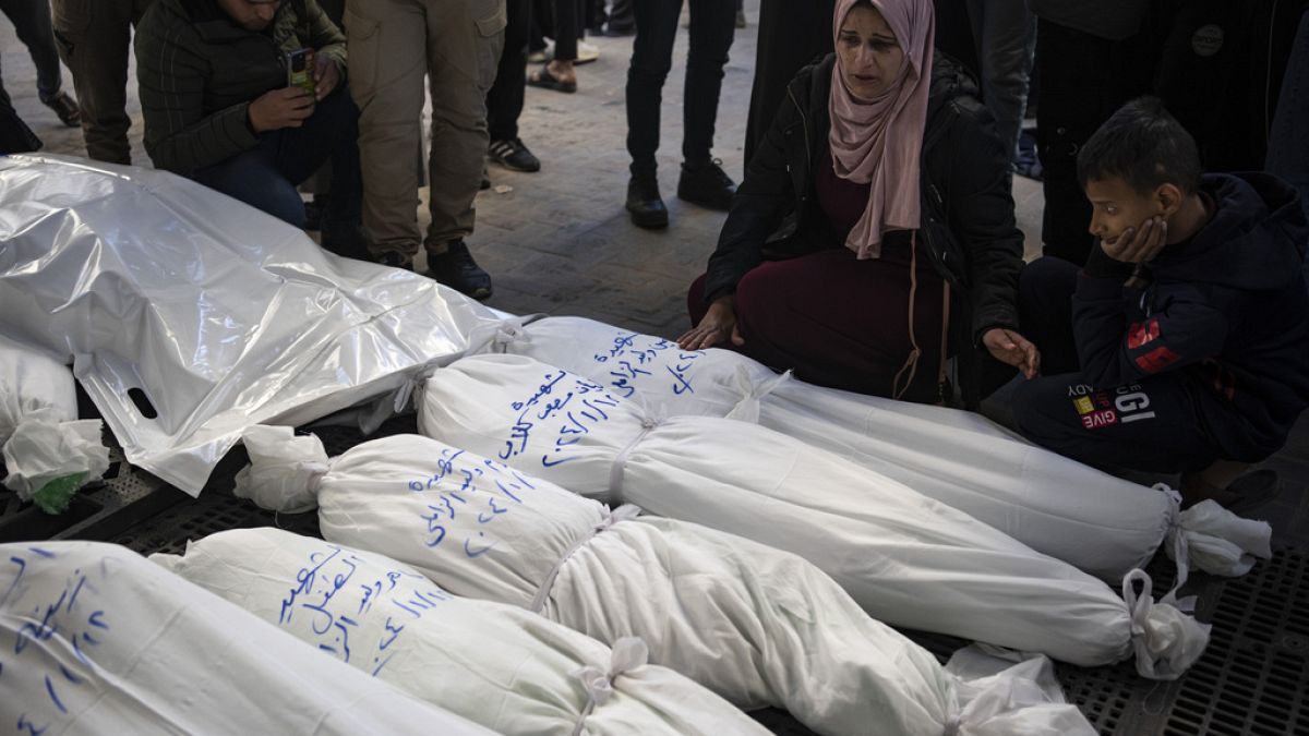 Palestinianos choram os seus familiares mortos nos bombardeamentos israelitas na Faixa de Gaza, à porta de uma morgue em Rafah, no sul de Gaza