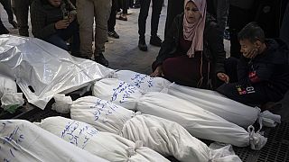 Palestinianos choram os seus familiares mortos nos bombardeamentos israelitas na Faixa de Gaza, à porta de uma morgue em Rafah, no sul de Gaza