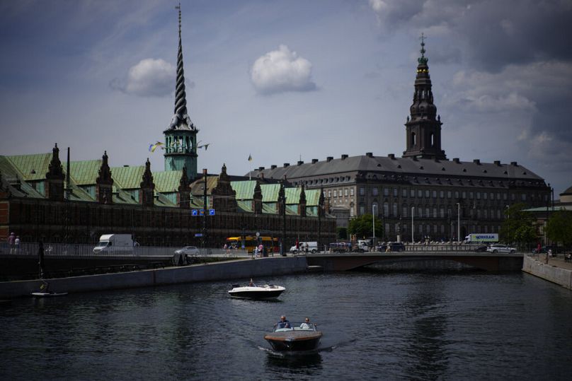 A boat wades through the Nyhavn river in Copenhagen, June 2022