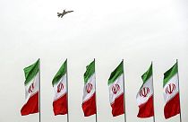 A fighter jet flies over Iranian flags during the army parade in Tehran