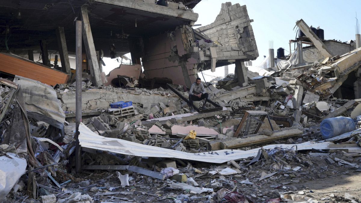 Egy palesztin ember ül az izraeli bombázások pusztításai között egy Gázai övezetben lévő menekülttáborban 2024. január 19-én.