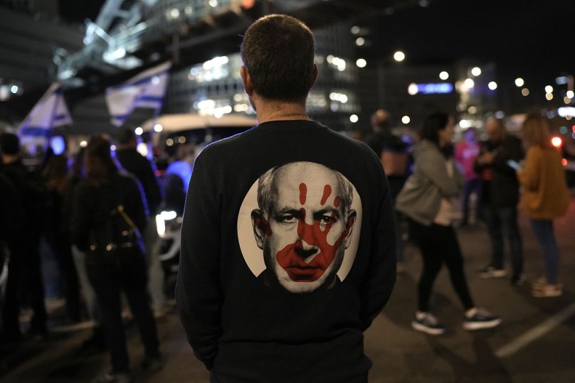 A protester wears a shirt depicting Israeli Prime Minister Benjamin Netanyahu attempt during a demonstration to demand the release of the hostages taken by Hamas militants