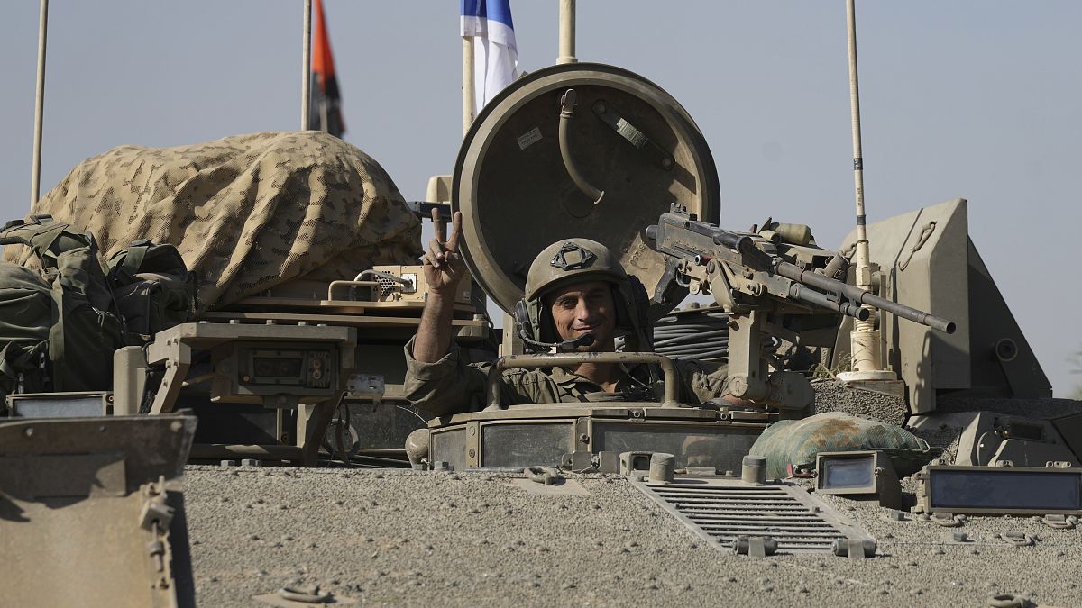 جندي إسرائيلي يرفع علامة النصر داخل مركبة تابعة للجيش الإسرائيلي بعد مغادرة غزة، يوم الجمعة، 24 نوفمبر، 2023.