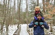 Christopher Roma carries his son Solomon on his shoulders in the White Mountains in New Hampshire in late 2023.