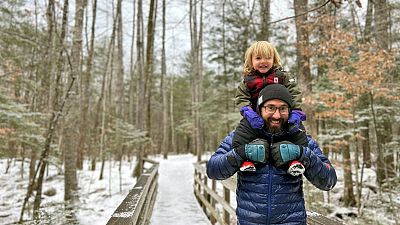 Christopher Roma carries his son Solomon on his shoulders in the White Mountains in New Hampshire in late 2023.
