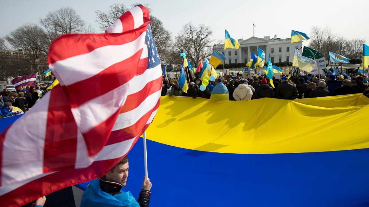 یک اوکراینی تبار در آمریکا با پرچم ایالات متحده در مقابل کاخ سفید در تظاهرات علیه تهاجم روسیه در سال ۲۰۱۴