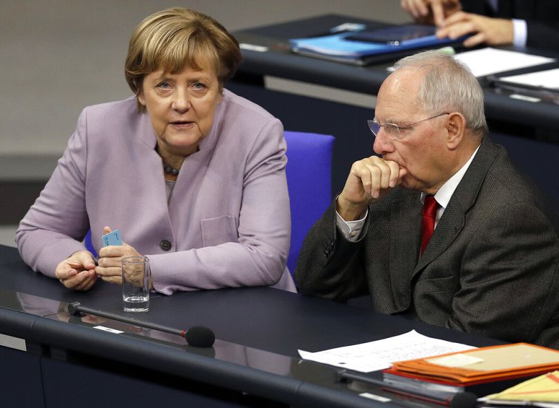 German Chancellor Angela Merkel, left, and German Finance Minister Wolfgang Schaeuble, right, talk during a budget debate at the German Federal Parliament in 2016t