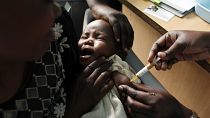 Une mère tient dans ses bras son bébé qui reçoit un nouveau vaccin contre le paludisme dans le cadre d'un essai au Kenya.