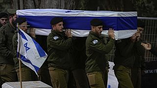 Soldados israelíes portan el féretro envuelto en una bandera del reservista Hadar Kapeluk durante su funeral en el cementerio militar de Monte Herzl en Jerusalén.