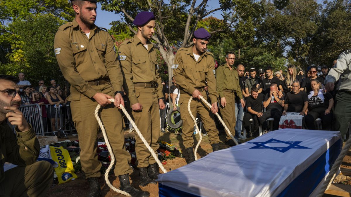 АРХИВ: израильские солдаты опускают гроб с телом погибшего товарища на военном кладбище Холона в пригороде Тель-Авива, Израиль, четверг, 2 ноября 2023 года. 