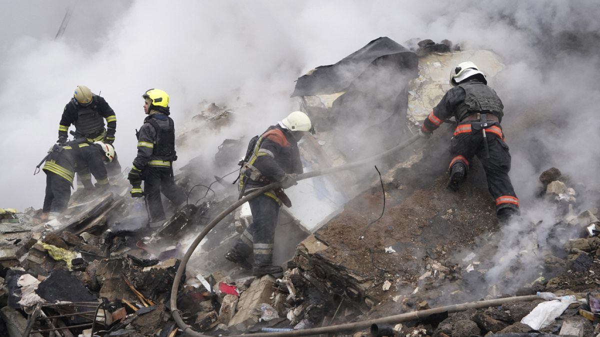 Des secouristes travaillent sur les lieux d'un bâtiment endommagé par une attaque à la roquette russe à Kharkiv, en Ukraine, le mardi 23 janvier 2024.
