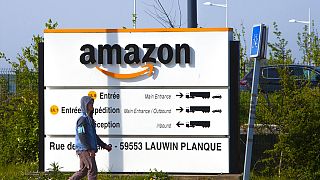A man walks at the entrance of Amazon, in Douai, northern France, Thursday April 16, 2020. 