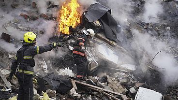 Des sauveteurs interviennent sur les lieux d'un bâtiment endommagé par une attaque à la roquette russe à Kharkiv, en Ukraine, le mardi 23 janvier 2024.