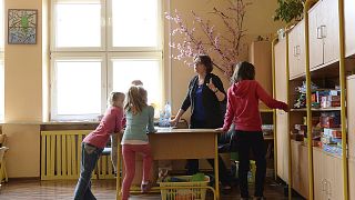 Egy tanárnő vigyáz az általános iskolás gyerekekre Varsóban 2017. március 31-én